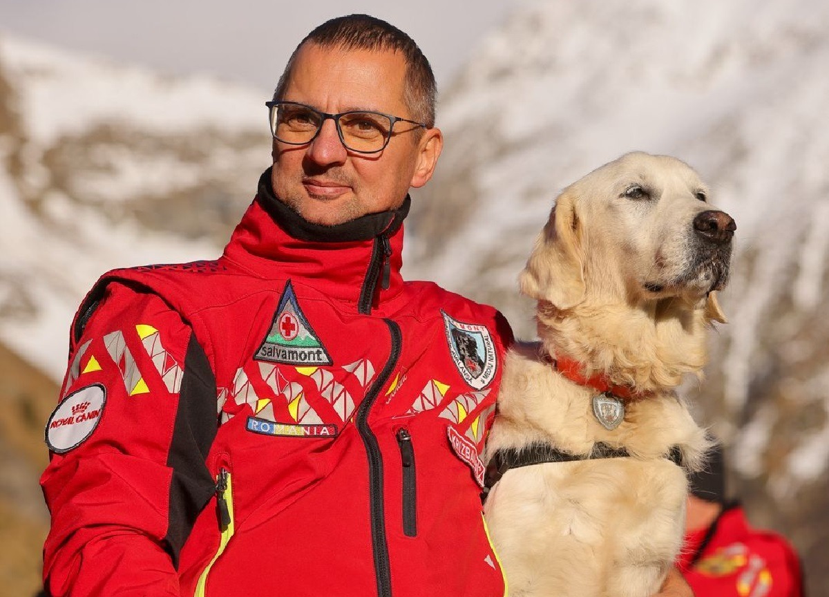 Câinele utilitar Yukanna alături de un salvator montan