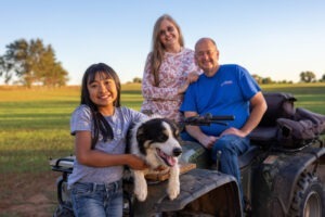 O familie alături de un câine Border Collie
