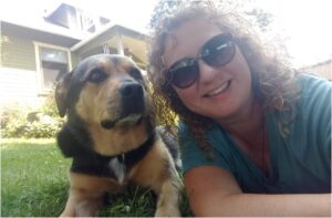 femeie cu ochelari de soare langa un caine