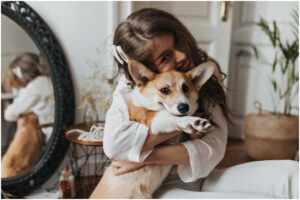 Femeie care îmbrățișează un câine Corgi