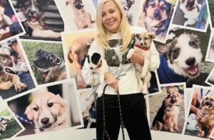 O femeie ține în brațe pui de câine la un târg de adopții