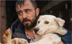 Medicul veterinar Mihai Grigorie în brațe cu unul dintre câinii salvați din adăpostul Suraia