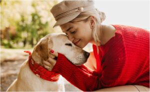 Un câine cu eșarfă este iubit de o femeie blondă