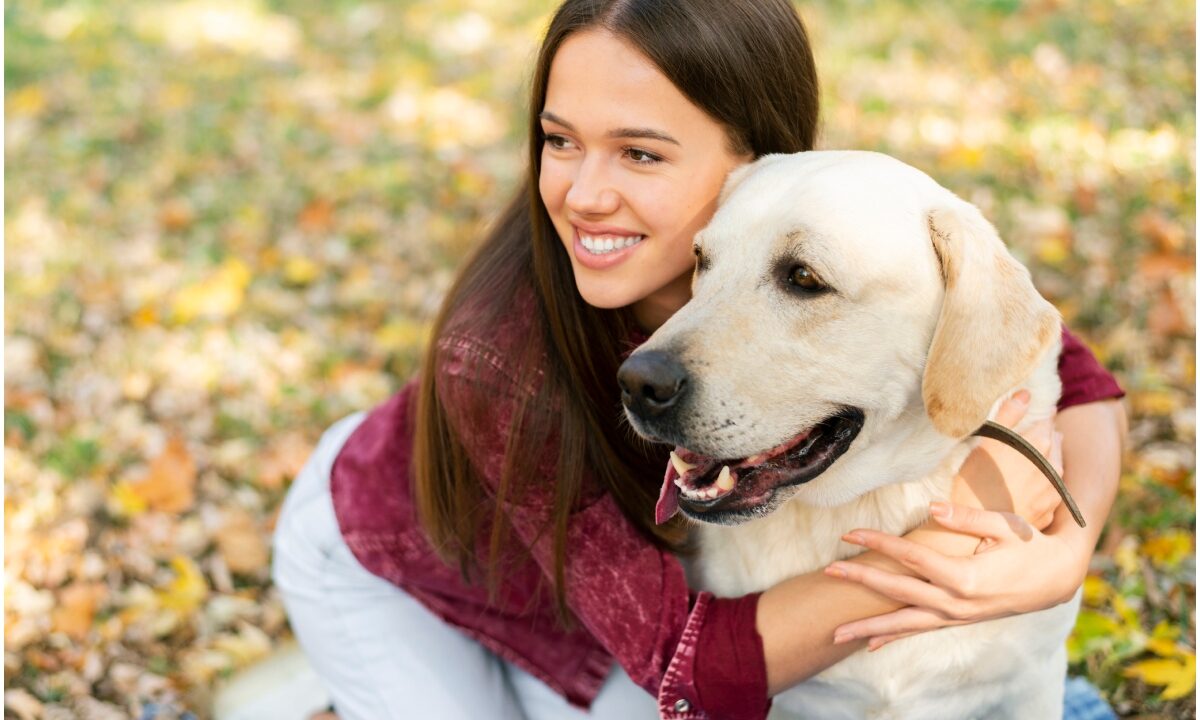 O femeie își îmbrățișează câinele