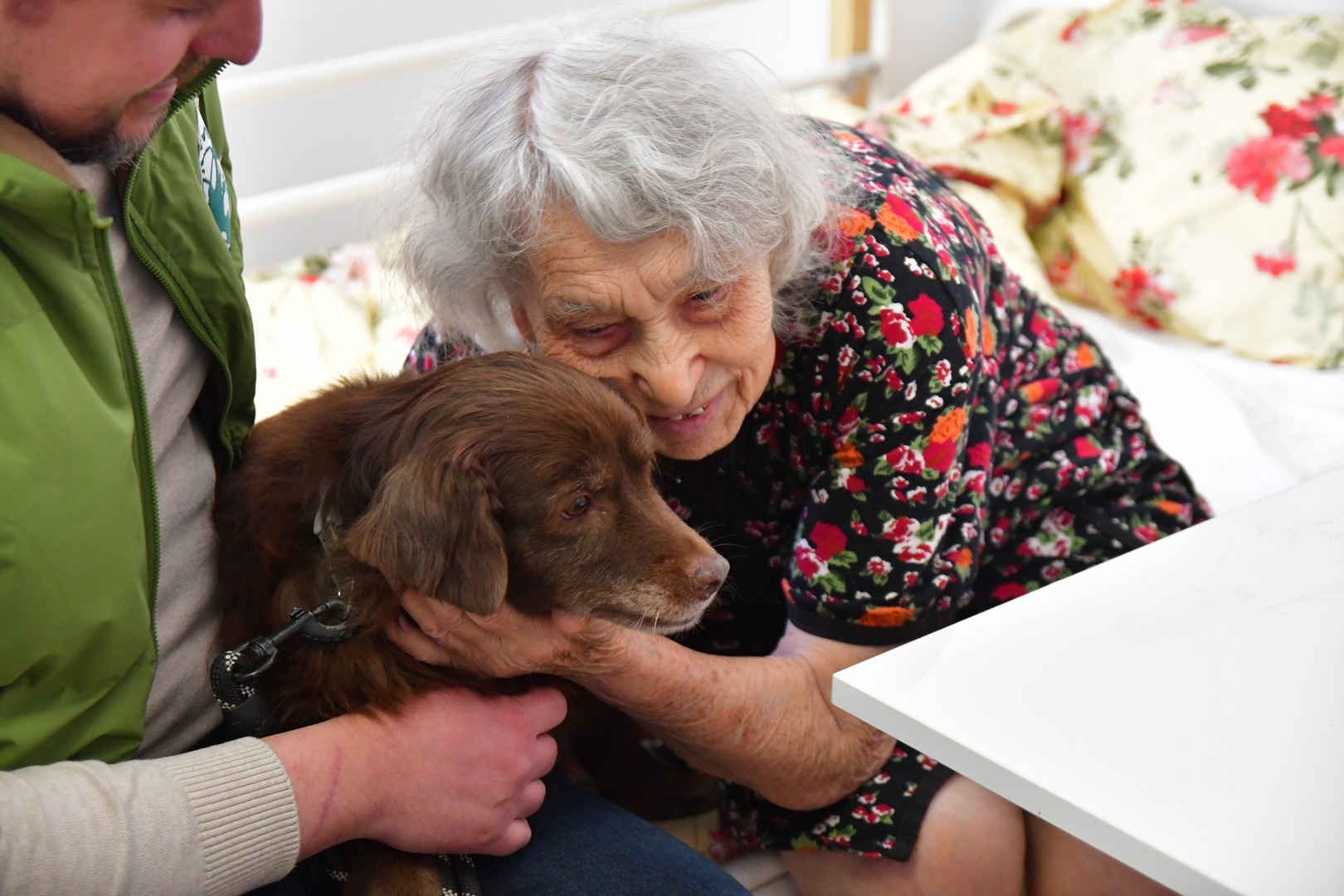 persoana varstnica alaturi de cainele Pispirica la Centrul Floare Rosie