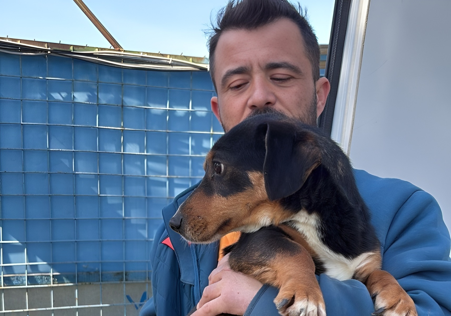 Mihai Grigore, medic veterinar, ține în brațe un câine salvat din adăpostul Aspa Ivets din Uzunu