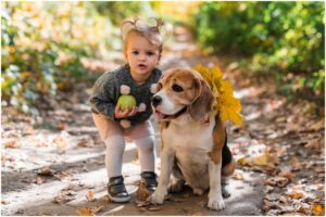 O fetiță lângă un câine Beagle pe o potecă din pădure