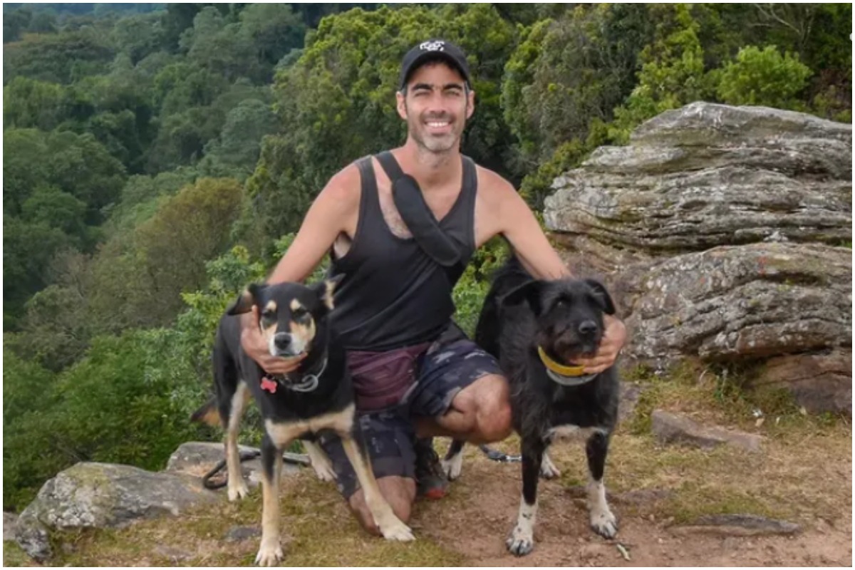 Un bărbat alături de cei doi câini ai săi