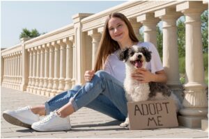 femeie și un câine lângă un gard