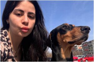 Femeie lângă un metis de Doberman