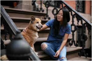 Femeie lângă un câine pe scări