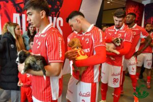 Jucătorii echipei Dinamo București intră pe teren însoțiți de câini salvați și dați spre adoptție, la meciul cu Universitatea Craiova, din Superliga